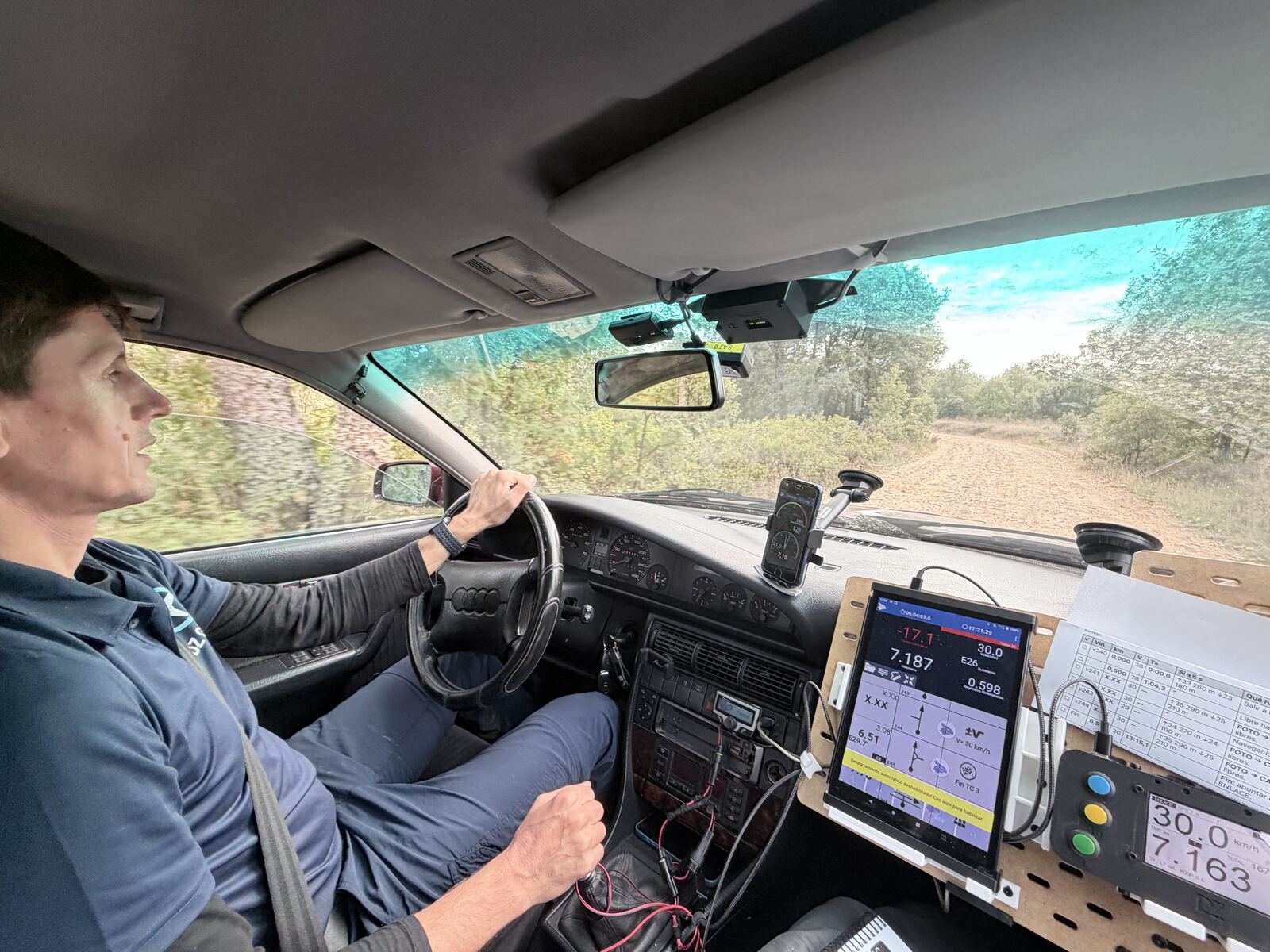 Andrés drives on a dirt road; on the right, the panel with the tablet reading 7.187 km and the cockpit 7.163 km